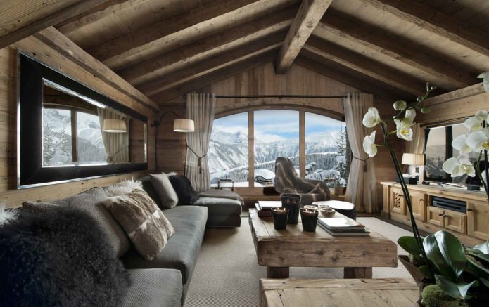 natural materials, wall decoration with wood, beams on the ceiling, wooden furniture and pillows made of skins and fur