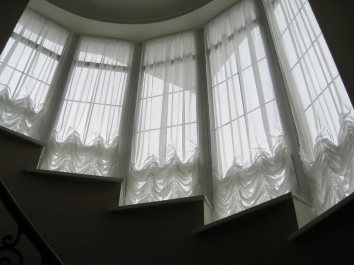 Austrian curtains on the windows along the stairs