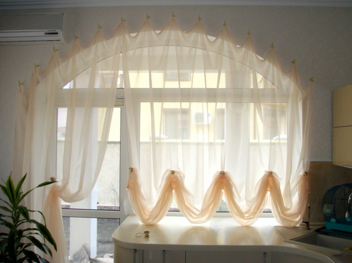 Austrian curtains on a window with a balcony door