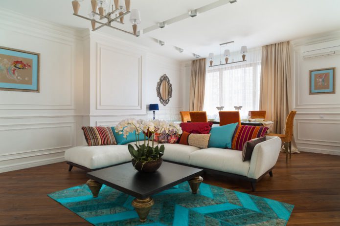 living room with turquoise carpet and pillows
