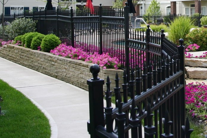 high flowerbed near a fence