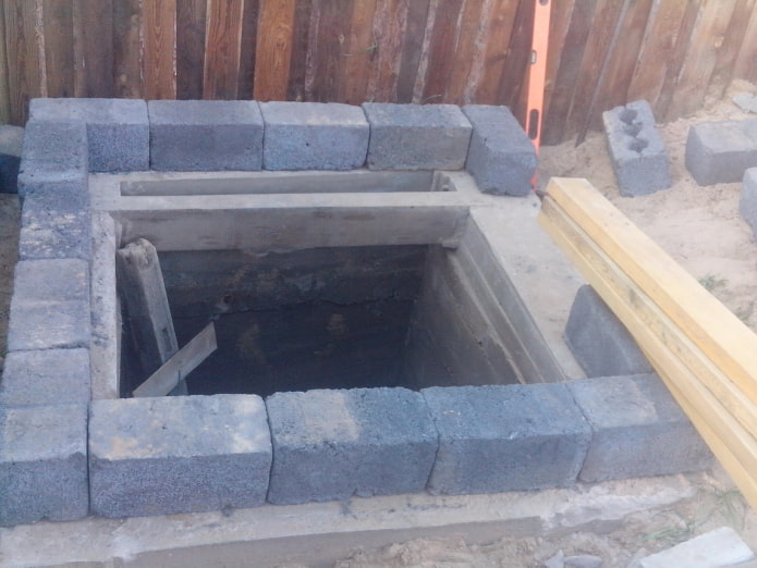 laying cinder block around the perimeter of the toilet
