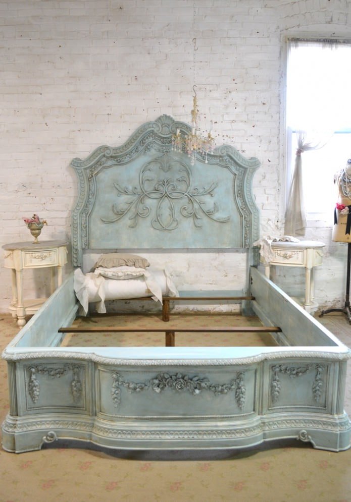 the bed and bedside tables are decorated with plaster moldings