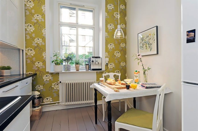 Green wallpaper with a floral pattern in the design of the kitchen in the Scandinavian style