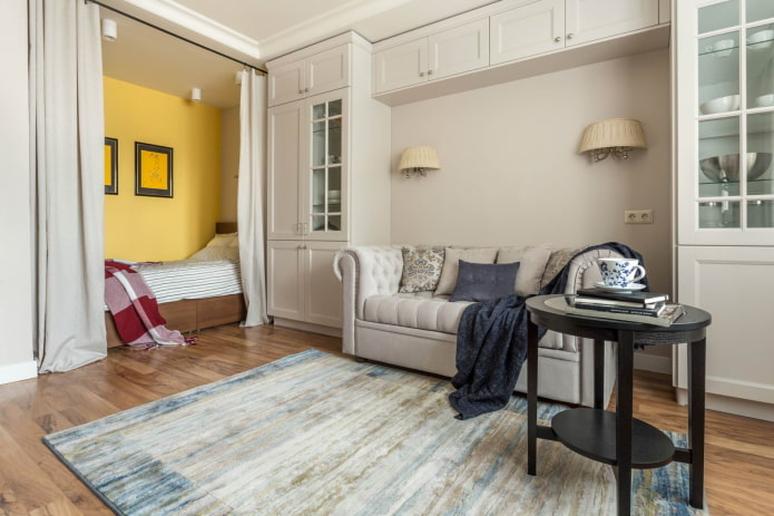 Bed behind curtains and a sofa in an arch