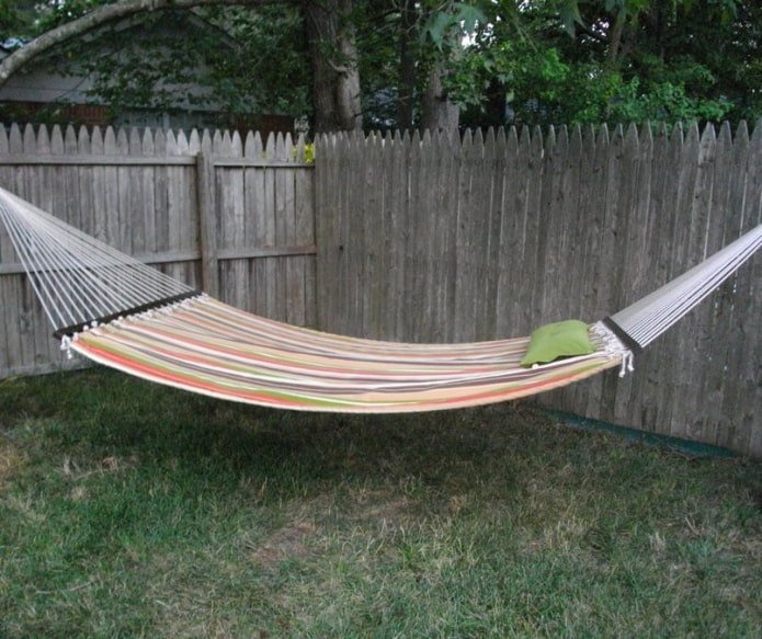 wide hammock attached to a wooden fence