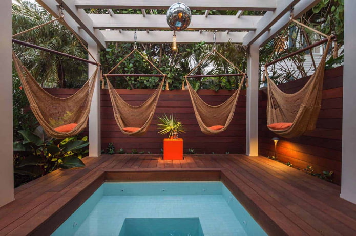 4 hammocks around the pool with a pergola