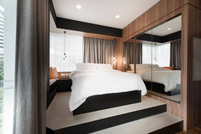 Bed on raised platform with mirror on side