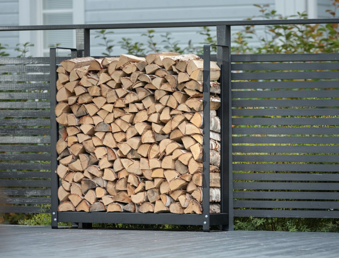 Woodpile near a metal fence