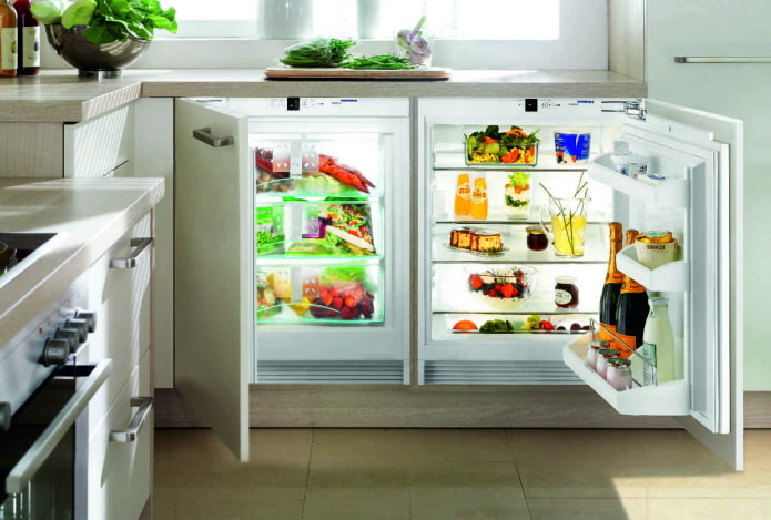 refrigerator under the countertop in the kitchen interior