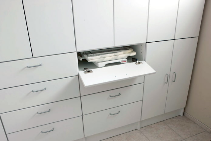 Folding ironing board in a cabinet drawer