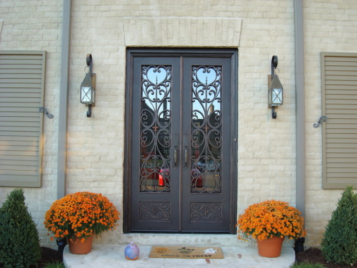 porch of a country house with an entrance door with forging and glass