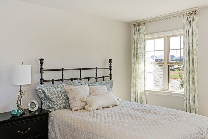 bed with forged headboard in the interior