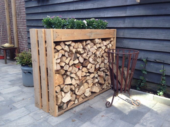 Woodpile with a flowerbed