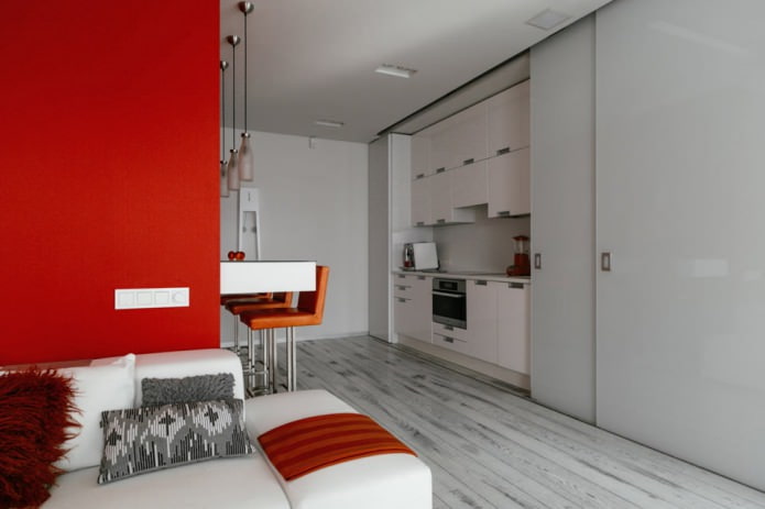Bar counter in the interior of the kitchen-living room in white and red tones