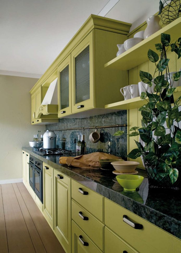 black countertop in a green kitchen