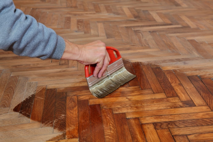 applying varnish to a wooden floor