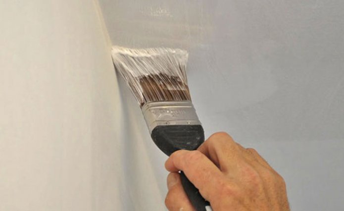 Painting the joints of the ceiling and walls with a brush