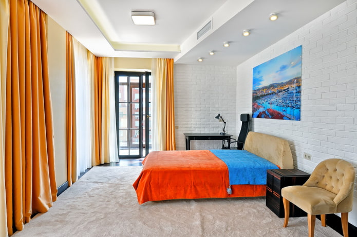 bed with an orange bedspread in the bedroom
