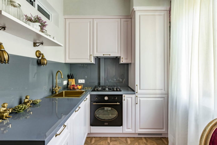 small kitchen with white furniture, gray countertops and an apron made of the same material