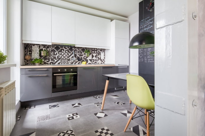gray and white kitchen with mosaics on the floor and on the apron