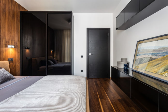 sliding wardrobe with a glossy facade in the bedroom interior