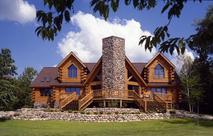 house made of rounded logs and stone with a brown roof