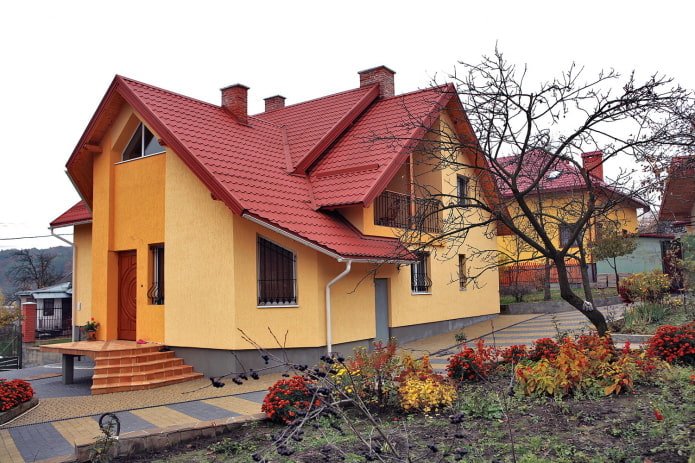 orange and yellow cottage with a red roof