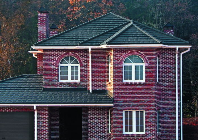 a house made of dark red brick with a black roof