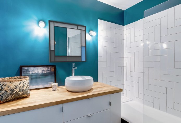 dark turquoise painted walls and white tiles in the bathroom
