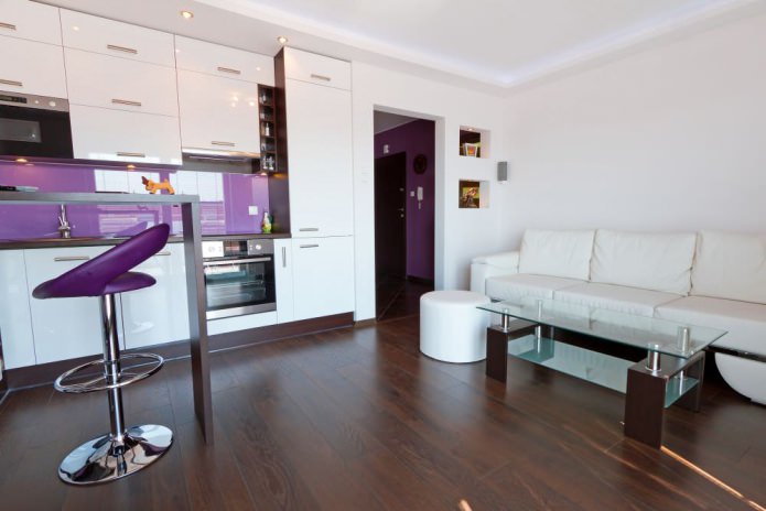 Design of a kitchen-living room with a bar counter in white and purple tones