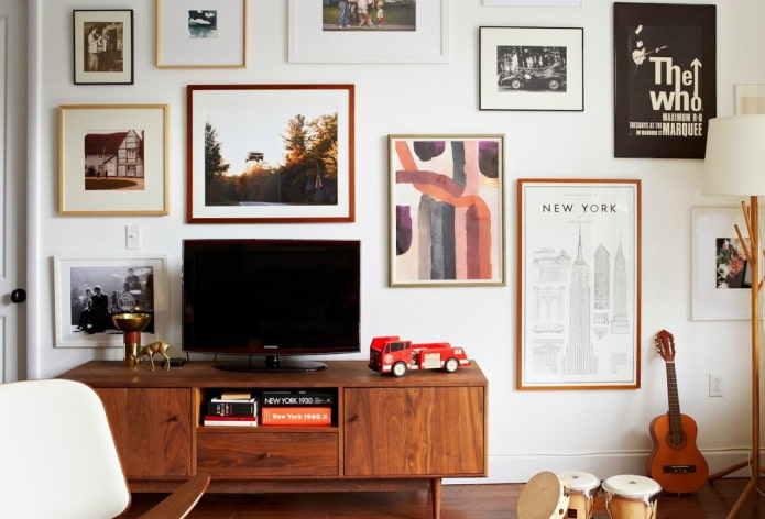 TV near the wall with paintings in the hall