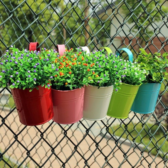 flower buckets on a chain-link fence