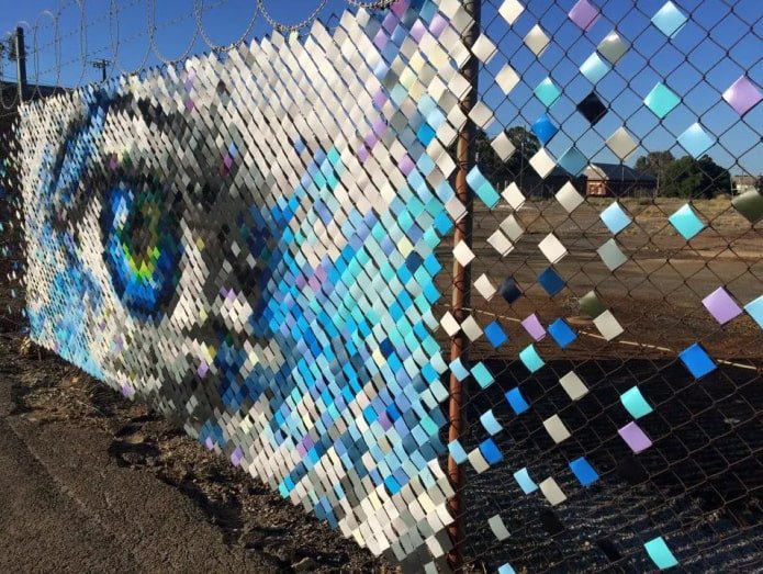 pattern of colored ribbons on a chain-link fence