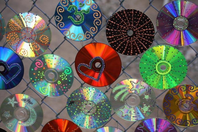compact discs on a chain-link fence