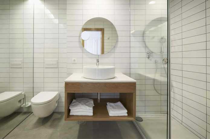 White bathroom with a shower and a hanging cabinet