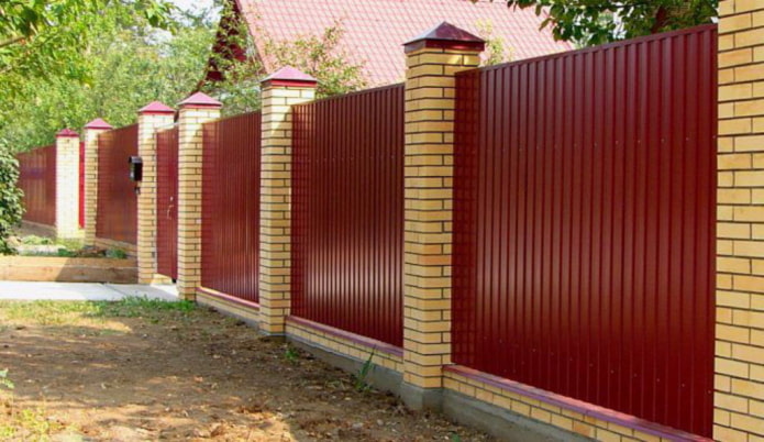 Fence made of corrugated sheet metal with brick columns