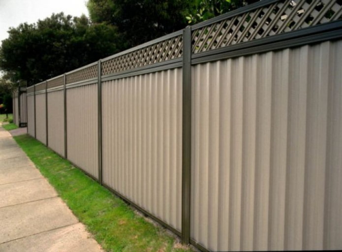 Fence made of beige corrugated sheet metal with decorative elements