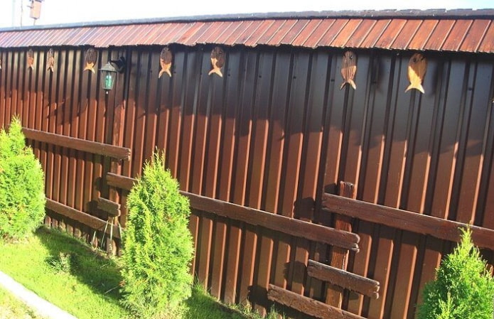 Unusual fence made of corrugated sheet metal with wood
