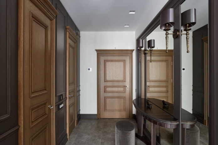 mirror with sconces in the interior of the hallway